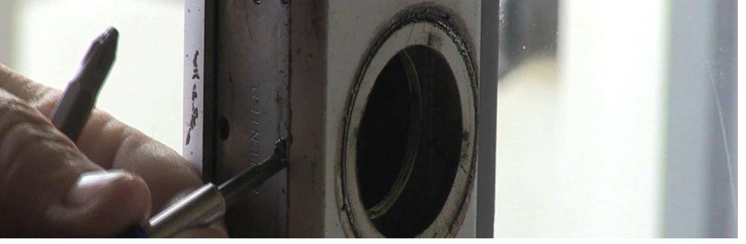 Locksmith working on a commercial door lock